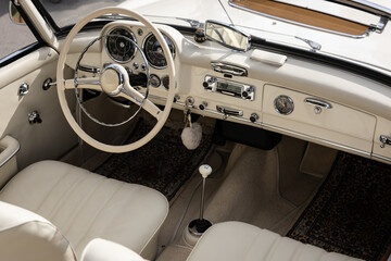Interior of a classic vintage car, white leather.
