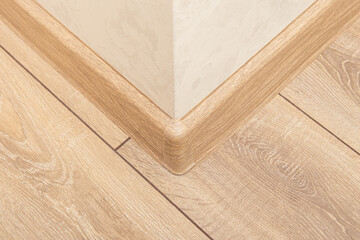 Plastic outer corner of floor skirting board. Plastic skirting boards with wood texture. Light...