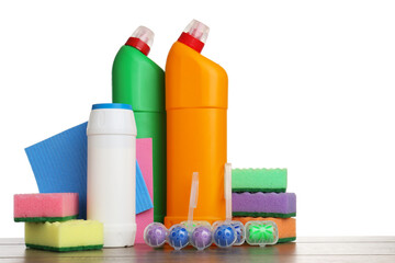 Different toilet cleaners, sponges and rag on wooden table against white background