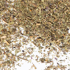 Dry basil spice seasoning macro texture on white background.