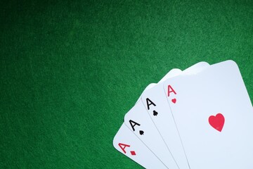 Poker game. Playing cards on green table, flat lay. Space for text