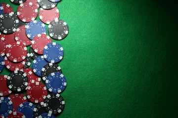 Poker chips on green table, flat lay. Space for text