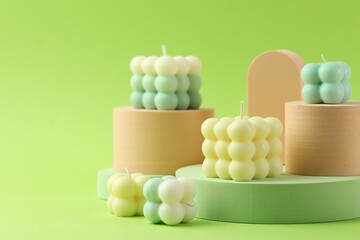 Beautiful bubble candles and geometric figures on green background
