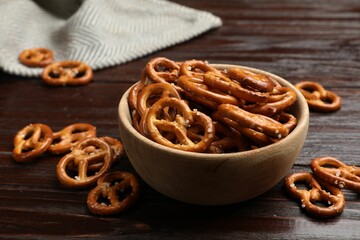 Tasty pretzel crackers on wooden table, closeup