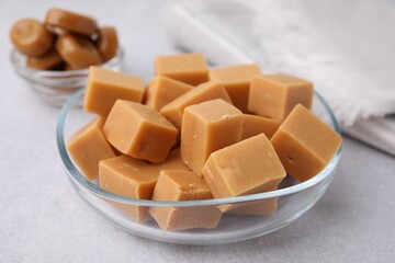 Tasty sweet caramel candies on light grey table, closeup