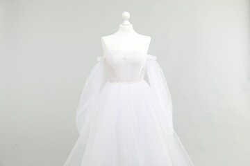 Mannequin with beautiful wedding dress on light grey background