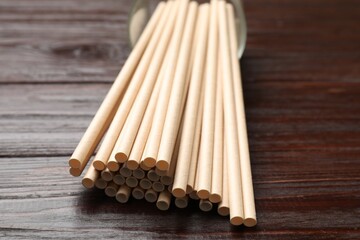 Bamboo drinking straws on wooden table, closeup