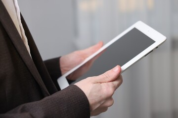 Businessman using tablet indoors, closeup. Modern technology