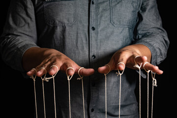 Close-up Of Man Controls The Puppet With Fingers. Man`s Hand Controls The Puppet With The Fingers...