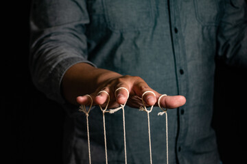 Close-up Of Man Controls The Puppet With Fingers. Man`s Hand Controls The Puppet With The Fingers...