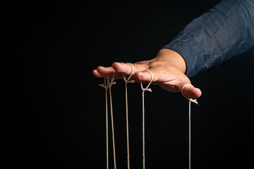 Close-up Of Man Controls The Puppet With Fingers. Man`s Hand Controls The Puppet With The Fingers...