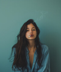 Fototapeta premium Portrait of a dark haired young woman with a cigarette in her mouth