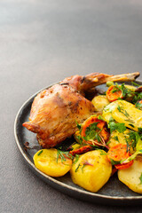 A hearty delicious dinner, baked rabbit with potatoes and carrots, a set table with food