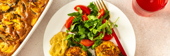 This nutritious breakfast features savory zucchini pancakes with fresh lettuce and tomatoes, paired with sweet cherry compote and a comforting peach pie, making for a wholesome meal, banner
