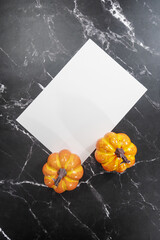 white sheet on black marble and halloween pumpkin