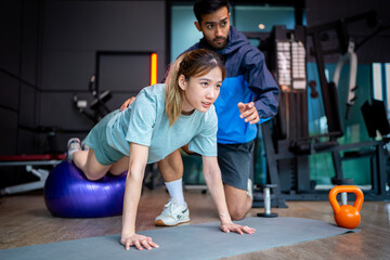 Asian man and woman working out, one is a trainer, the other is an exerciser