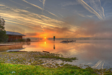 Sonnenaufgang bei Morgennebel an einem See 