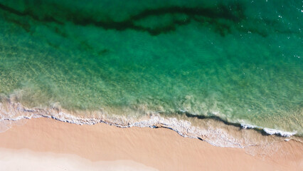 Aerial view of the beautiful turquoise sea with algae in Comporta, Portugal