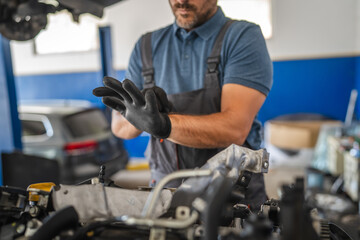 Car mechanic wear gloves preparing to work on vehicle engine