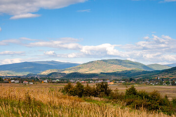 countryside of ukraine. sunny afternoon. autumn landscape in mountains. grassy field and rolling hills. rural scenery