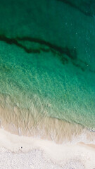 Aerial view of the beautiful turquoise sea with algae in Comporta, Portugal
