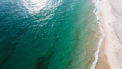 Aerial view of the beautiful turquoise sea with algae in Comporta, Portugal