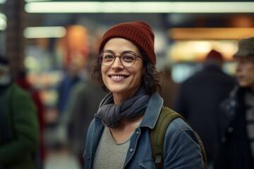Fototapeta premium Portrait of a happy woman in her 40s donning a warm wool beanie isolated in busy supermarket aisle background