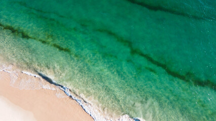 Aerial view of the beautiful turquoise sea with algae in Comporta, Portugal
