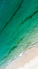 Aerial view of the beautiful turquoise sea with algae in Comporta, Portugal