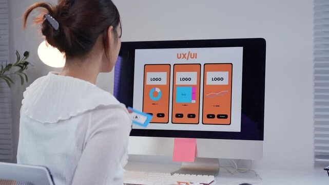 Young web designer is creating a mobile application, placing different wireframe elements on a screen