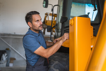 Car mechanic inspect heavy machinery in workshop setting indoors