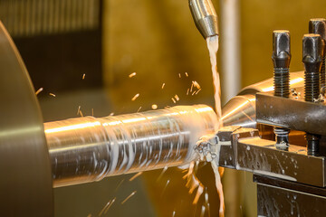The lathe machine finish cut  metal shaft parts with liquid coolant method.