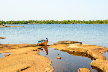 sea kayak pulled up on the rocky shore of a georgian bay island in september