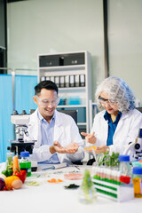 Team Asian scientists in a lab conducting food research using a microscope and lab equipment, showcasing innovation