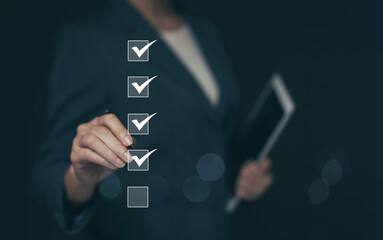 Business performance checklist concept Young business woman using laptop surveys online checklist...