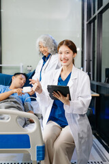 Obraz premium Hospital Ward Male and Male Professional Asian Doctors Talk with a Patient, Give Health Care Advice,