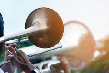 Man playing trumpet in public park. Close up of male hands playing trumpet. © Sophon_Nawit