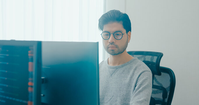 Young adult Asia male freelance eyeglasses typing write prompt AI bot IT app smart program nomad, video game, terminal with coding, user interface, designer, big data center on desktop computer.