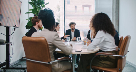 Sales department discussing ways of improvement for company income. Listening to different ideas. Comparing data or information with last quarter.