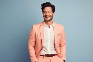 Portrait of a happy man in his 20s dressed in a stylish blazer over pastel or soft colors background