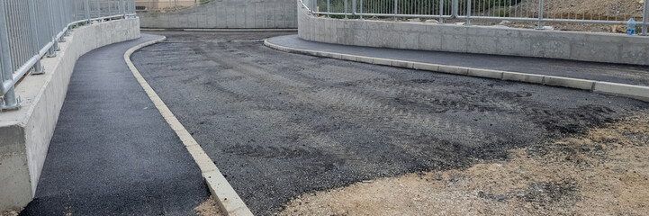 Fototapeta premium Newly paved road and sidewalk under construction, representing infrastructure development and urban planning concepts