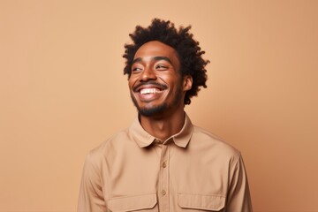 Portrait of a joyful afro-american man in his 20s sporting a breathable hiking shirt on pastel or soft colors background