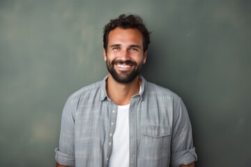Fototapeta premium Portrait of a satisfied man in his 30s dressed in a relaxed flannel shirt in front of minimalist or empty room background