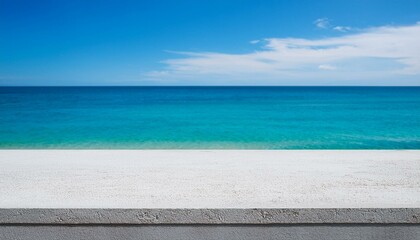 Fototapeta premium Concrete table top against the background of the sea on the beach. Empty white countertop for product presentation with blue water and sky. Outdoor mockup