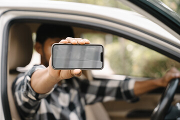 Man Holding Smartphone in Car: A close-up photo of a man's hand holding a smartphone with a blank screen, showcasing its potential for mobile marketing, technology, and social media.