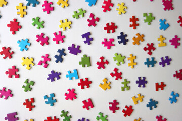 Colorful jigsaw puzzle pieces on white background. Flat lay.