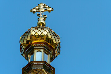 The golden dome and the cross of the Orthodox church. The old building of the Orthodox Church against the blue sky.