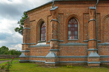 Obraz premium The Catholic church. The old red brick church. A historical building with a religious purpose.