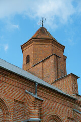 The Catholic church. The old red brick church. A historical building with a religious purpose.