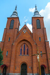 Fototapeta premium The Catholic church. The old red brick church. A historical building with a religious purpose.